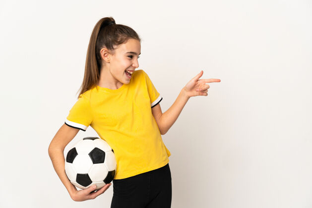 球员一个小足球运动员 一个被隔离在白墙上的女人 手指着旁边 展示着一个产品手势游戏女孩