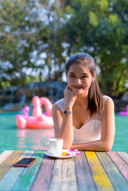 成人年轻美丽的亚洲女游客在湖边户外放松的画像年轻衣服船
