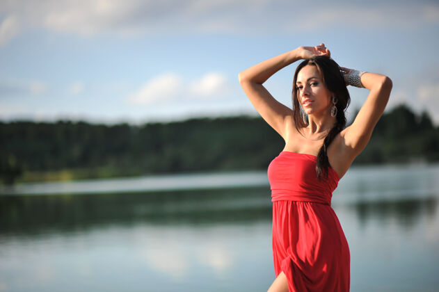 模特夏天的年轻女子红色长裙在户外摆姿势人自然夏天