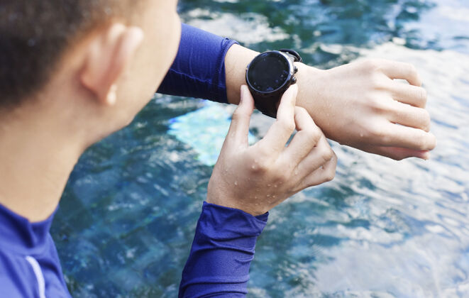 人游泳池里有心率监测器的游泳运动员男子防水运动