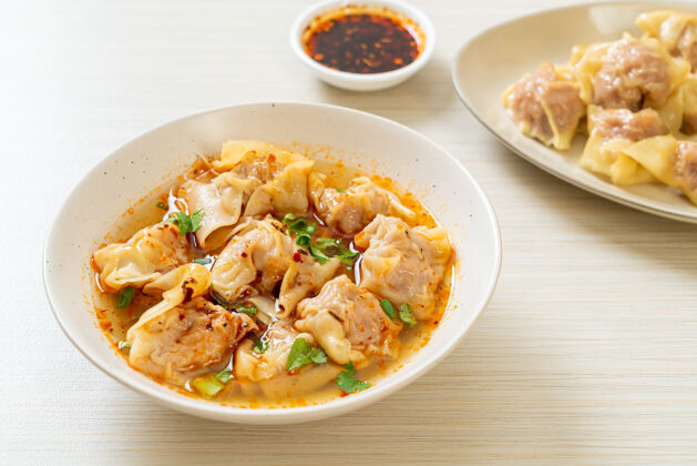 餐厅猪肉馄饨汤或猪肉饺子汤配烤辣椒-亚洲风味美味饺子亚洲菜