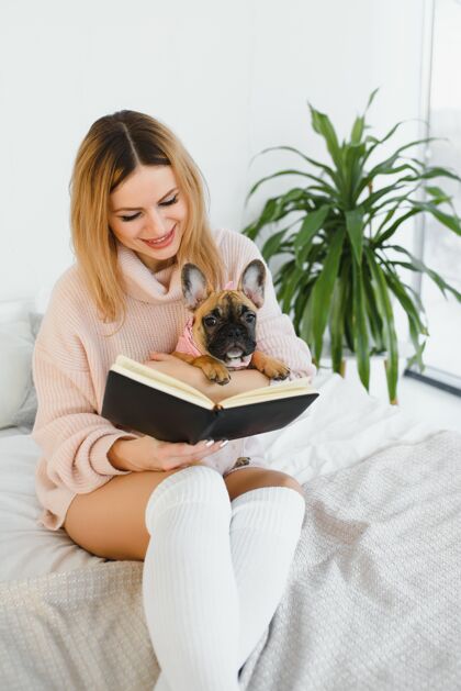 黑发女孩在读一本书书可爱女孩和她的狗在一起看书家漂亮时尚女孩漂亮沙发年轻