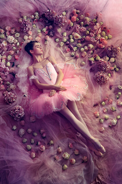 芭蕾舞演员温暖的思绪美丽的年轻女子在粉色芭蕾舞团的俯视图 花团锦簇珊瑚光下的春天意境和温柔艺术照片春天的概念 花朵和大自然的觉醒年轻姿势芭蕾舞
