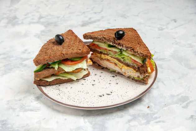 晚餐正面特写美味三明治与黑面包装饰橄榄在一个盘子上染色白色表面青蛙午餐橄榄