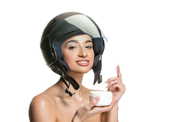 安全在白色工作室背景上 一个戴着摩托车头盔的漂亮女人的肖像美丽 皮肤和面部保护的概念司机皮肤治疗