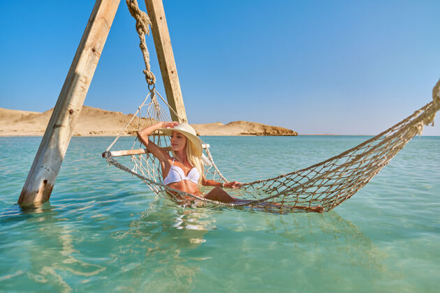 海滩旅行和度假的概念妇女放松吊床在海上休闲海洋埃及