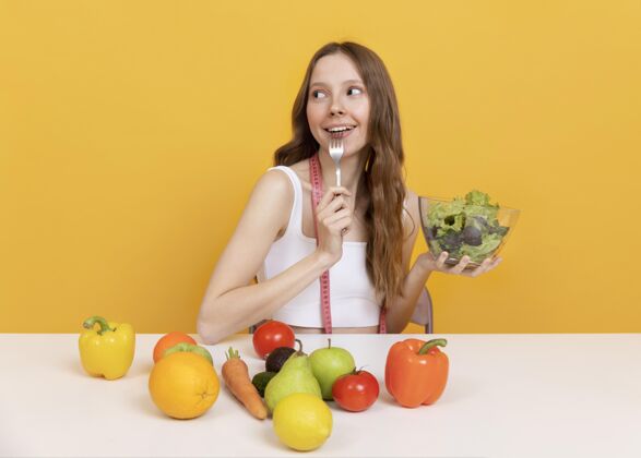 饮食中等身材的女人和蔬菜保健中镜头食物