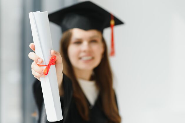 大学毕业：拿着毕业证书的学生站帽子肖像