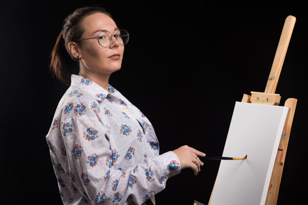 女人女画家用黑色的铅笔在画布上画画爱好画家绘画