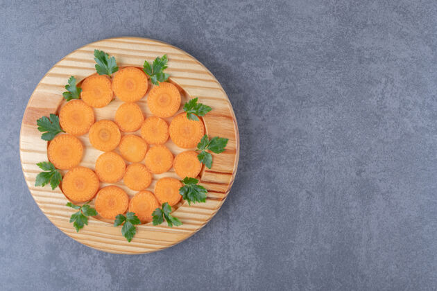 生的一小块胡萝卜和青菜 放在大理石表面营养风味盘子
