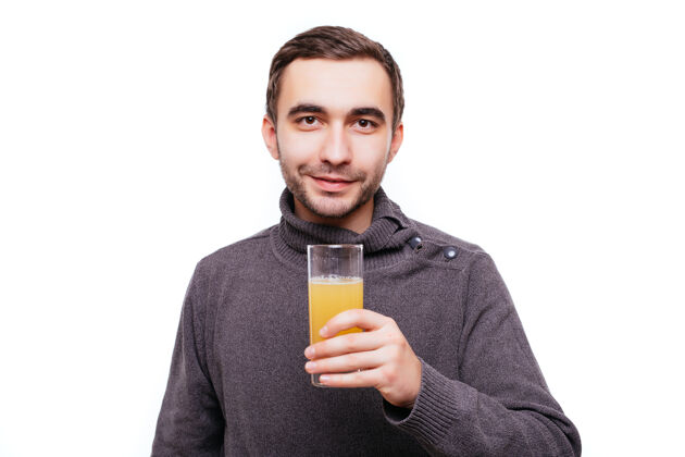 胡须快乐的胡子男人拿着一杯橙汁 在白色的墙上孤立地竖起大拇指杯子成人选择