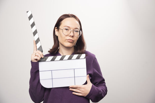 模型一个年轻的女人在一张白色的照片上摆着一个电影院的带子高质量的照片镜头年轻人女性