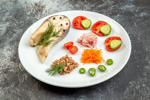 冰水煮鱼荞麦的特写镜头 在冰面上的白色盘子上放着绿色的蔬菜 有自由空间美食蔬菜起来