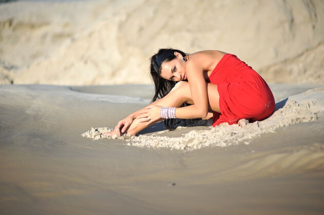 女人穿着红裙子在沙滩上发冷的女人海洋度假天空