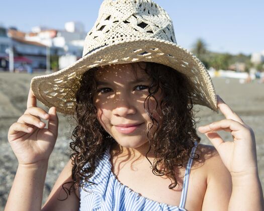 假期特写海滩上戴帽子的女孩乐趣孩子放松
