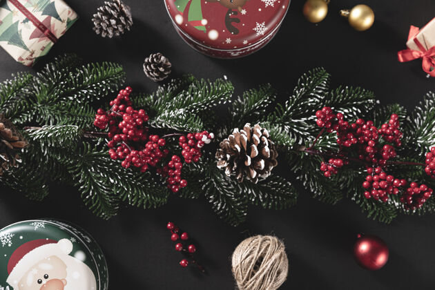 快乐顶视图拍摄松枝与锥和礼物在一个黑色的桌子-圣诞节的概念盒子松树季节
