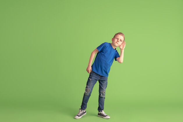 孩子快乐的男孩在绿色的画室墙上玩得开心多彩欢呼表情