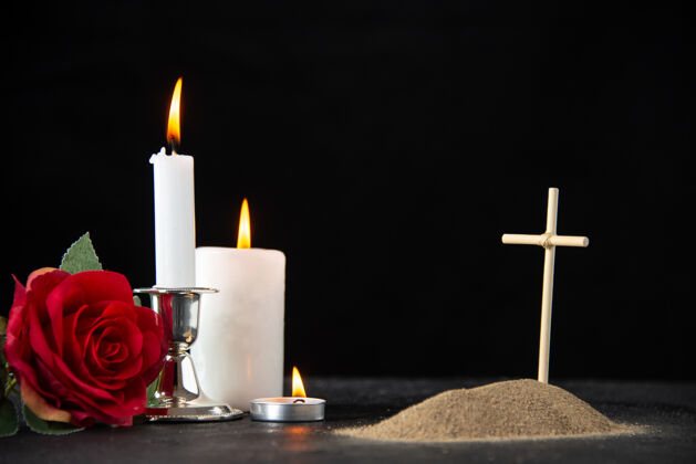 蜡烛红色玫瑰和黑色蜡烛的小坟墓正面图红火焰打蜡