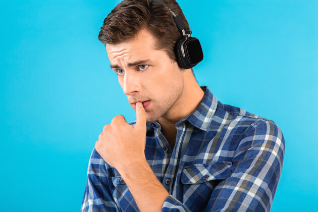 音频时尚帅气的年轻人 戴着无线耳机听音乐 享受着现代风格的快乐心情耳机科技自信