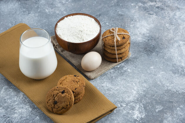 美味一杯热牛奶和美味的饼干放在一张灰色的桌子上鸡蛋面粉好吃