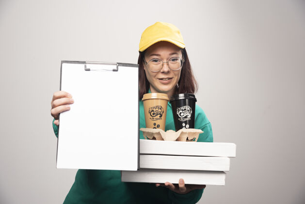 模特女送货员拿着咖啡杯和笔记本上的白色高品质的照片女士纸板年轻人