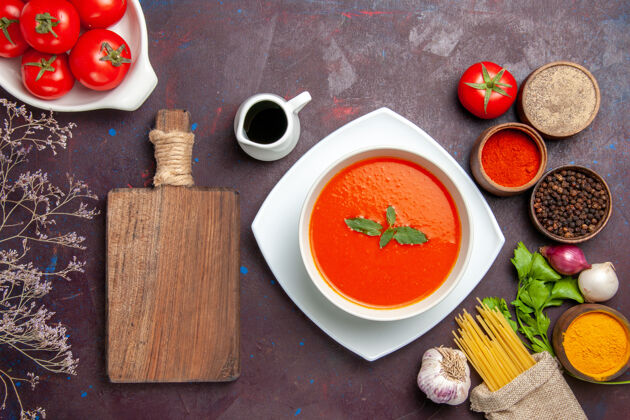 新鲜俯瞰美味的西红柿汤配上新鲜的西红柿和调味料 背景为深色的菜肴酱番茄色汤景观调味品盘子