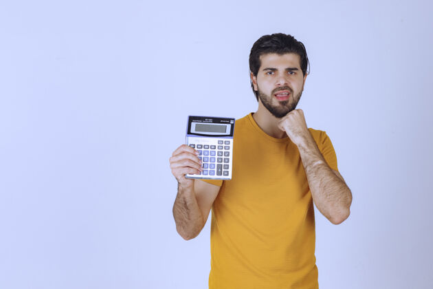 人类穿黄衬衫的人在计算器上计算着什么姿势男性财务