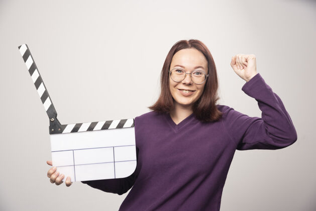镜头一个年轻的女人在一张白色的照片上摆着一个电影院的带子高质量的照片人类磁带女人