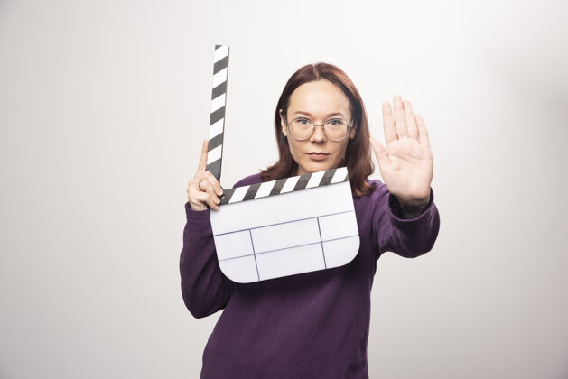 人类一个年轻的女人在一张白色的照片上摆着一个电影院的带子高质量的照片镜头姿势女士