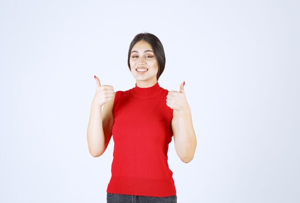 满意穿红衬衫的女孩展示着快乐的手势工人姿势员工
