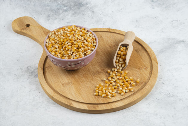砧板一碗生玉米粒 用勺子放在木板上勺子堆谷类