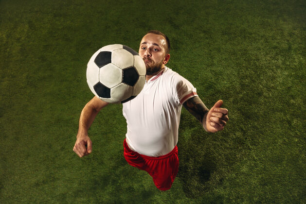 联赛白种人足球或足球运动员在草地上的绿色背景俯视图年轻男性运动模型训练 练习 踢球 进攻 接球运动概念 比赛 胜利男子运动动作