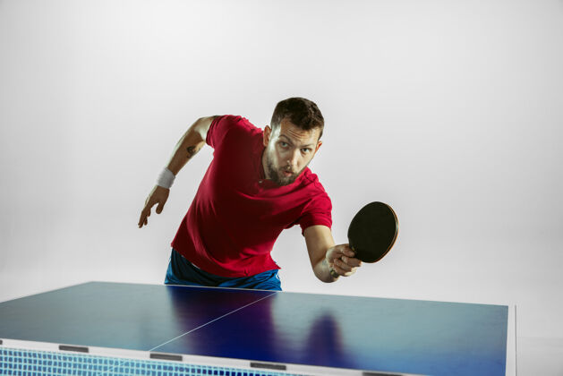 球拍年轻人在白墙上打乒乓球运动装乒乓球球员