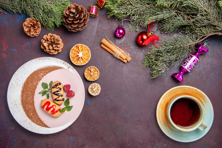 饼干俯瞰美味的甜饼干与一杯茶和圣诞树在一个黑暗的背景饼干甜饼干糖彩色蛋糕顶部早餐食物