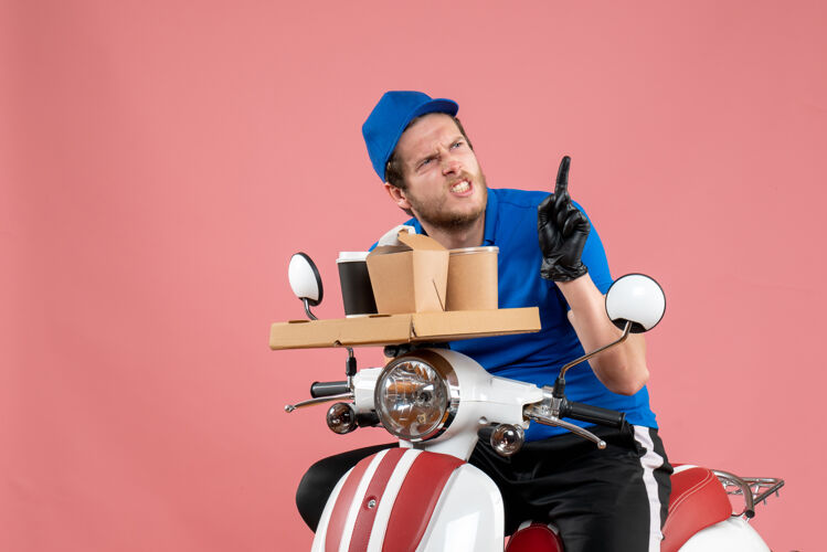 服务正面图身着蓝色制服的男快递员手持咖啡和食品盒上的粉色快餐工作送货工作自行车颜色服务景观制服颜色