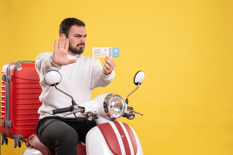 男旅游概念与愤怒的男子坐在摩托车上 手提箱上显示黄色的车票黄色比赛运动