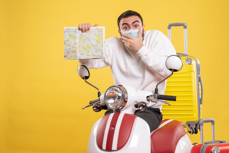 旅行顶视图的旅游概念与惊讶的家伙在医疗面具站在摩托车附近人手提箱黄色