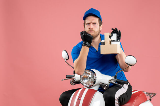 工人正面图身穿蓝色制服的男快递员拿着咖啡骑在粉色的工作快餐送货服务工自行车上蓝色自行车运动