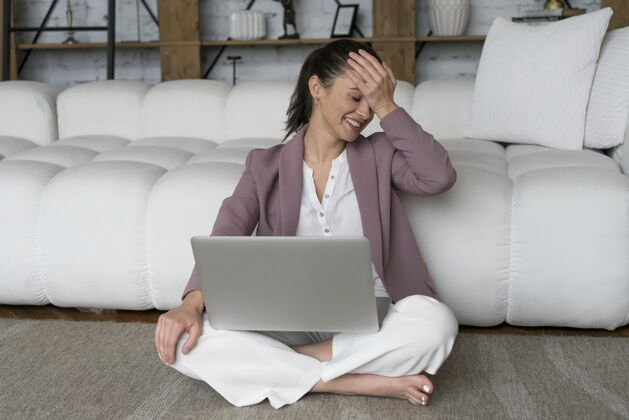 笔记本电脑坐在地板上膝上放着笔记本电脑的女人科技设备科技