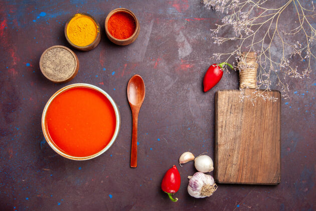 顶部俯瞰美味的西红柿汤 用新鲜的西红柿和调味料烹制而成 背景为深色的西红柿汤 酱面为红色油漆番茄创意