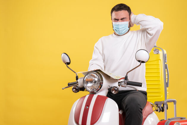 黄色一个戴着医用口罩的神经兮兮的家伙坐在摩托车上 背着黄色手提箱 手里拿着地图 头痛不已地图运动医疗