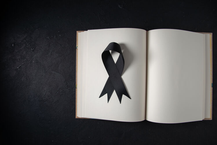 葬礼黑色墙上打开的书里面的黑色蝴蝶结俯视图死亡战士黑色蝴蝶结