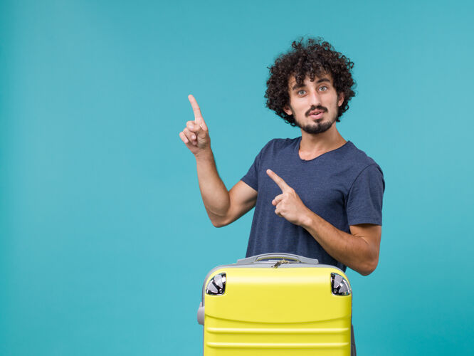 成人带着蓝色黄手提箱的度假男人肖像旅行人物