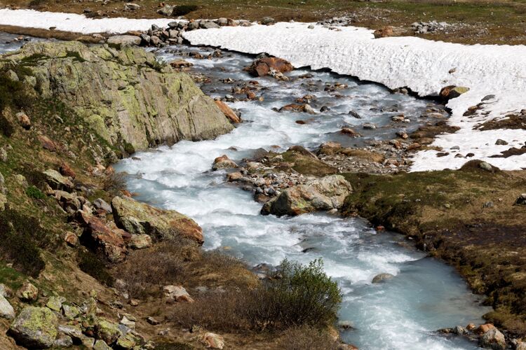 溪流位于瑞士苏斯腾山口的山河在冬天的白天瑞士冰石头