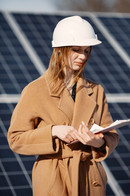 维护在太阳能发电厂检查设备的女商人使用平板电脑清单 在太阳能发电厂户外工作的女商人技术平板电脑工程师