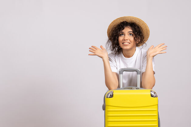 微笑正面图年轻女性 带着黄色的包 准备乘坐白色背景的阳光色航程度假飞机旅游航班飞行旅行美丽
