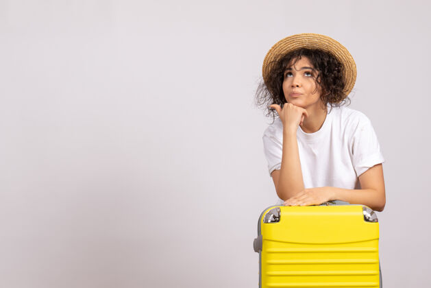 美丽正面图年轻女性带着黄色的包准备乘坐白色背景色的航班休息航程飞机旅游度假飞行休息年轻女性