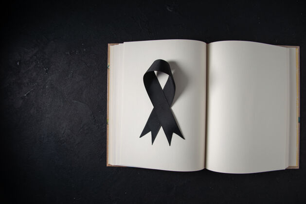 葬礼黑色墙上打开的书里面的黑色蝴蝶结俯视图死亡战士黑色蝴蝶结