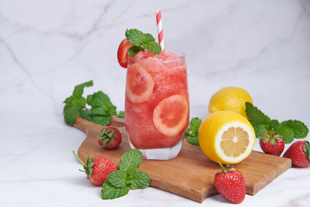 冷藏美味的草莓和柠檬冰沙点缀着新鲜的草莓和薄荷柔和的焦点美丽的开胃品粉红草莓 健康和减肥的概念营养木材提神