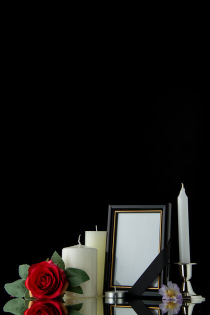 白蜡烛黑墙上带相框的白色蜡烛的正面图黑暗死亡图画